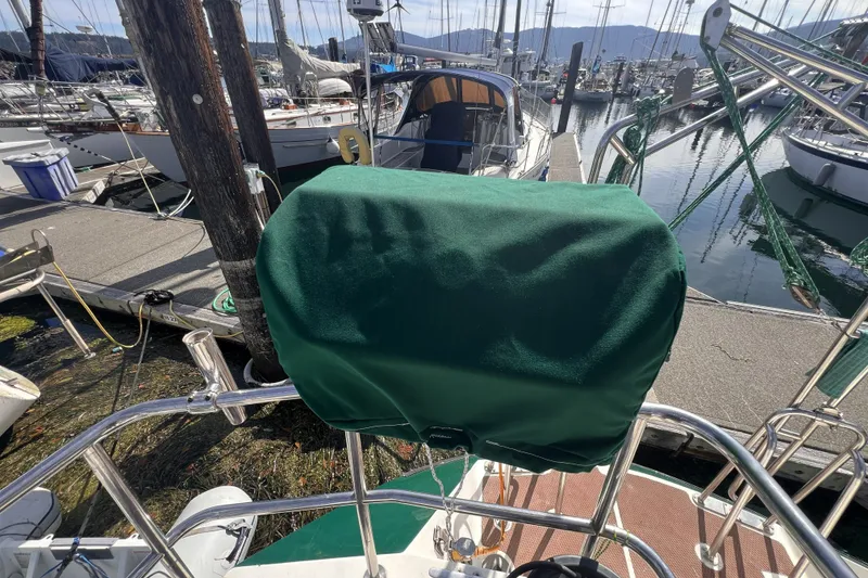 Slide: The Image of Sailboat docked at marina, featuring a green-covered helm, Perry 51 model, 1991. - 41