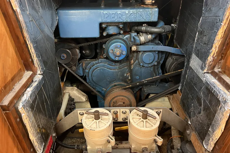 Slide: The Image of Engine compartment of a 1991 Perry 51, featuring a Perkins engine with visible belts and components. - 98