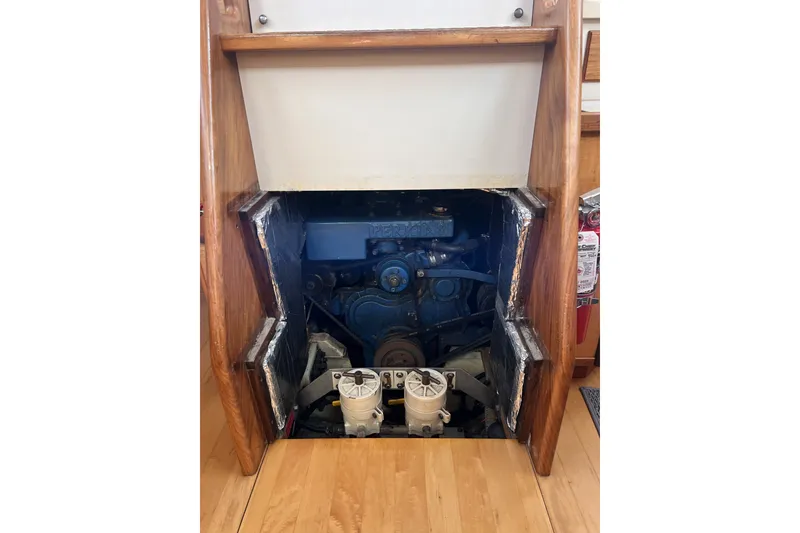 Slide: The Image of Engine compartment of a 1991 Perry 51 boat, showcasing mechanical components and wooden framing. - 99