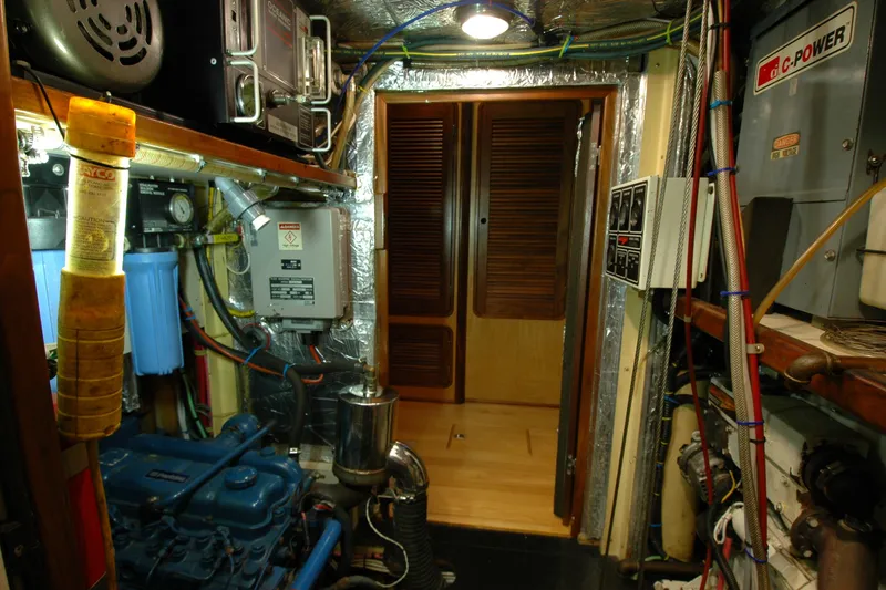 Slide: The Image of Engine room of a 1991 Perry 51 yacht, featuring machinery and control panels. - 95
