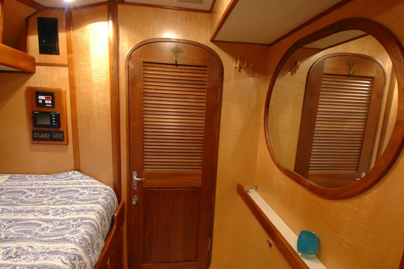 Slide: The Image of Cozy cabin interior of 1991 Perry 51 yacht with wooden accents and round mirror. - 80