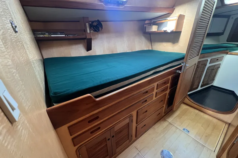 Slide: The Image of Cozy cabin interior of 1991 Perry 51 yacht with wooden furnishings and green bedding. - 86