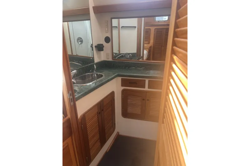 Slide: The Image of 1991 Perry 51 yacht bathroom with wooden cabinets and green countertop. - 91