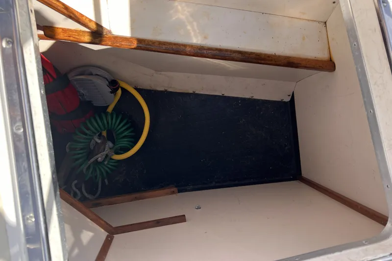 Slide: The Image of Storage compartment in a 1991 Perry 51 boat with hoses and equipment. - 46