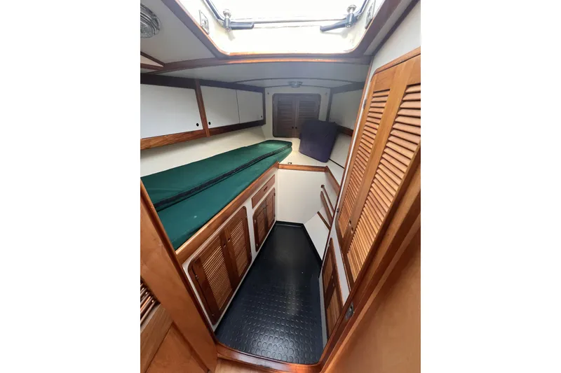 Slide: The Image of Cozy cabin interior of 1991 Perry 51 yacht with wooden accents and green bedding. - 87
