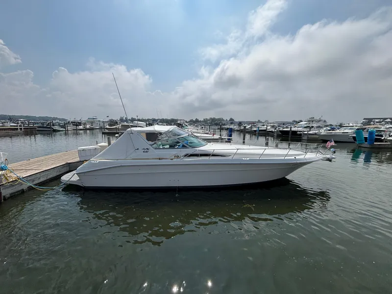 Slide: The Image of 1992 Sea Ray 400 EXPRESS yacht docked at marina under cloudy sky. - 1