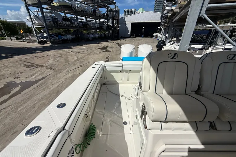Slide: The Image of 2015 Jupiter 34 FS boat interior with white seating and docked boats in background. - 26