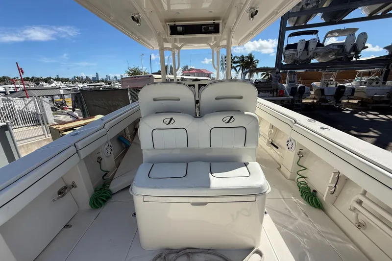 Slide: The Image of 2015 Jupiter 34 FS boat interior with seating, docked under clear blue sky. - 27