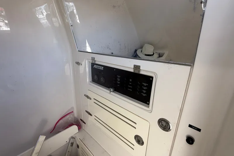 Slide: The Image of Control panel inside 2015 Jupiter 34 FS boat, featuring switches and storage compartments. - 19