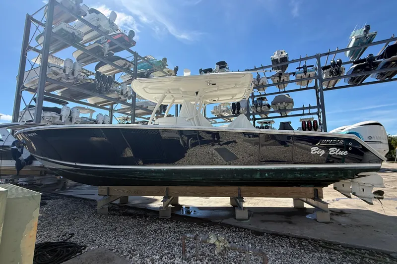 Slide: The Image of 2015 Jupiter 34 FS boat named "Big Blue" on a storage rack under clear blue sky. - 13