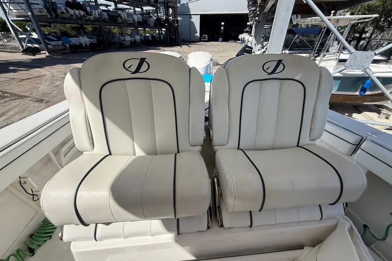 Slide: The Image of 2015 Jupiter 34 FS boat seats, white leather with black trim, in a marina setting. - 25