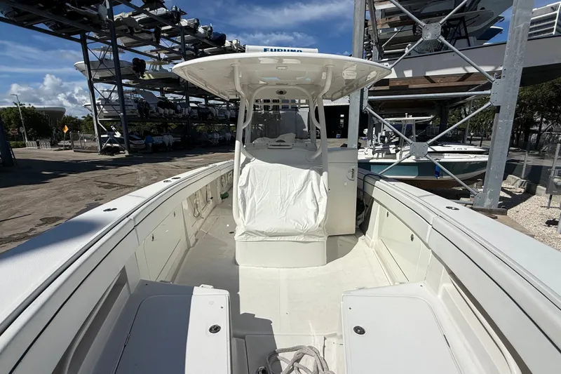 Slide: The Image of 2015 Jupiter 34 FS boat docked, showcasing spacious deck and helm under clear skies. - 23