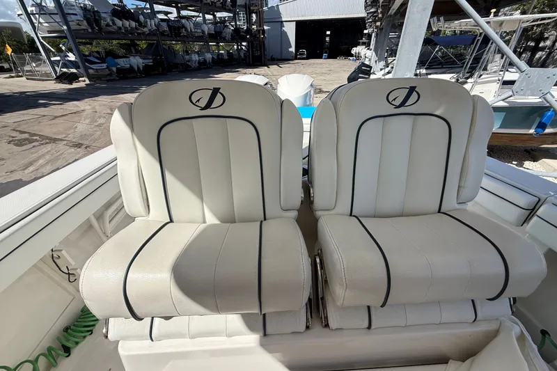 Slide: The Image of Two white cushioned seats on a 2015 Jupiter 34 FS boat. - 24