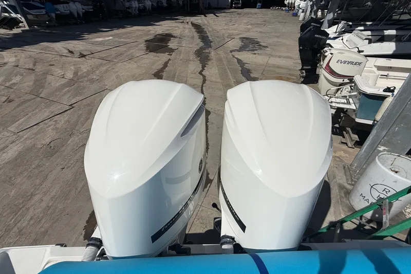 Slide: The Image of Twin outboard engines on a 2015 Jupiter 34 FS boat in a marina setting. - 14