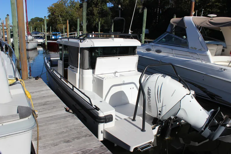 Slide: The Image of 2019 Axopar Brabus 28 Cabin boat docked with Mercury outboard engine. - 7