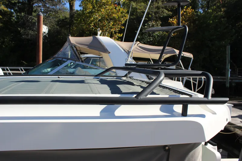 Slide: The Image of 2019 Axopar Brabus 28 Cabin boat docked, featuring sleek design and sturdy railings. - 10
