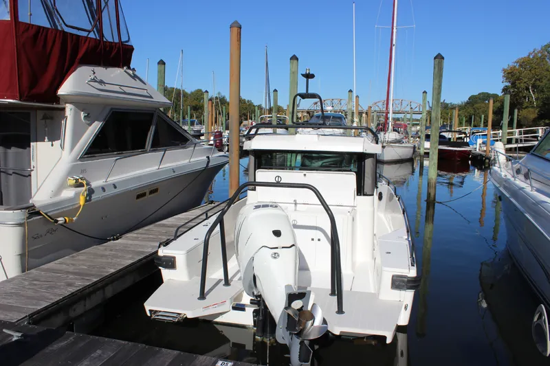 Slide: The Image of 2019 Axopar Brabus 28 Cabin docked at a marina, surrounded by other boats. - 6