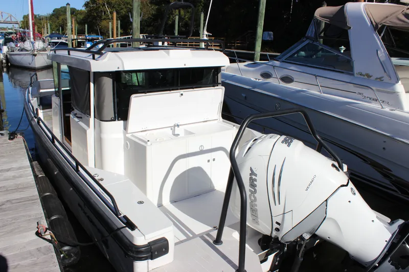Slide: The Image of 2019 Axopar Brabus 28 Cabin boat docked, featuring a powerful Mercury outboard engine. - 25
