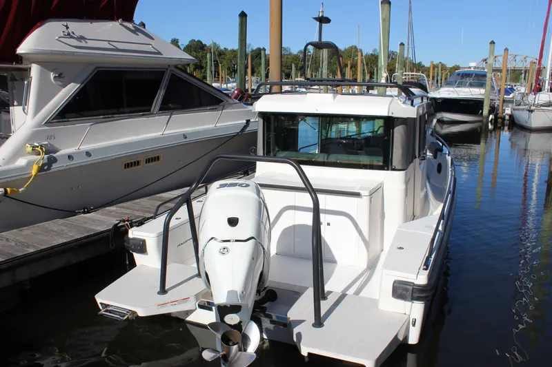 Slide: The Image of 2019 Axopar Brabus 28 Cabin boat docked at marina, rear view. - 0