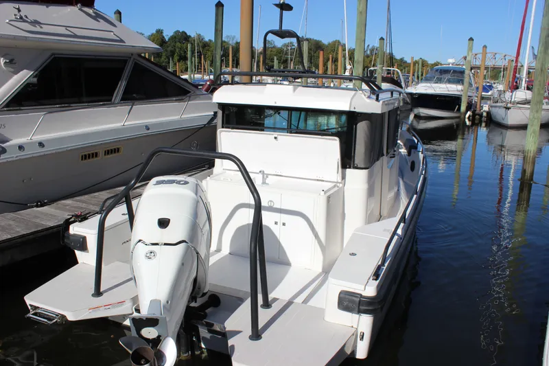 Slide: The Image of 2019 Axopar Brabus 28 Cabin boat docked at a marina, rear view. - 26