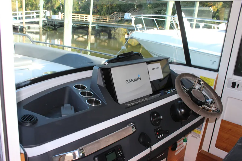 Slide: The Image of 2019 Axopar Brabus 28 Cabin helm with Garmin navigation system and steering wheel. - 19
