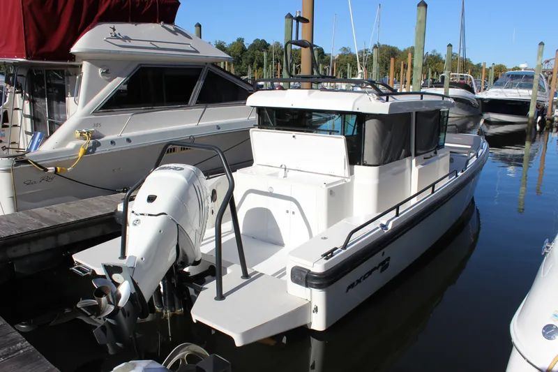 The Image of 2019 Axopar Brabus 28 Cabin boat docked at marina, featuring sleek design and powerful outboard motor. - 5