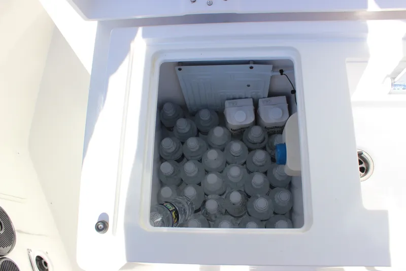 Slide: The Image of Cooler filled with bottled water and cartons on a 2019 Axopar Brabus 28 Cabin boat. - 22