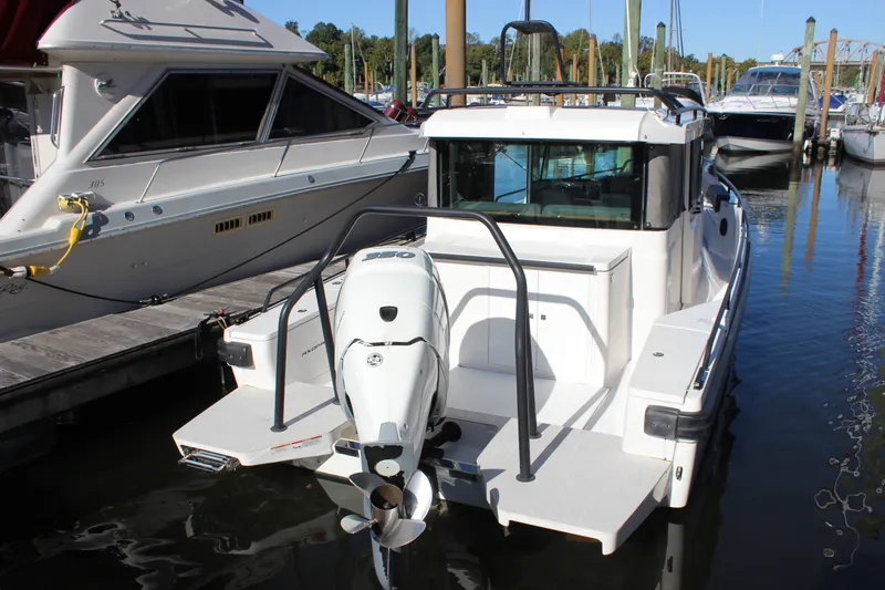 Slide: The Image of 2019 Axopar Brabus 28 Cabin boat docked with outboard motor visible. - 3
