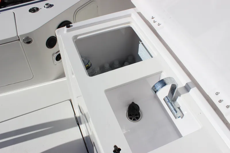 Slide: The Image of 2019 Axopar Brabus 28 Cabin boat sink and storage area with water bottles. - 23