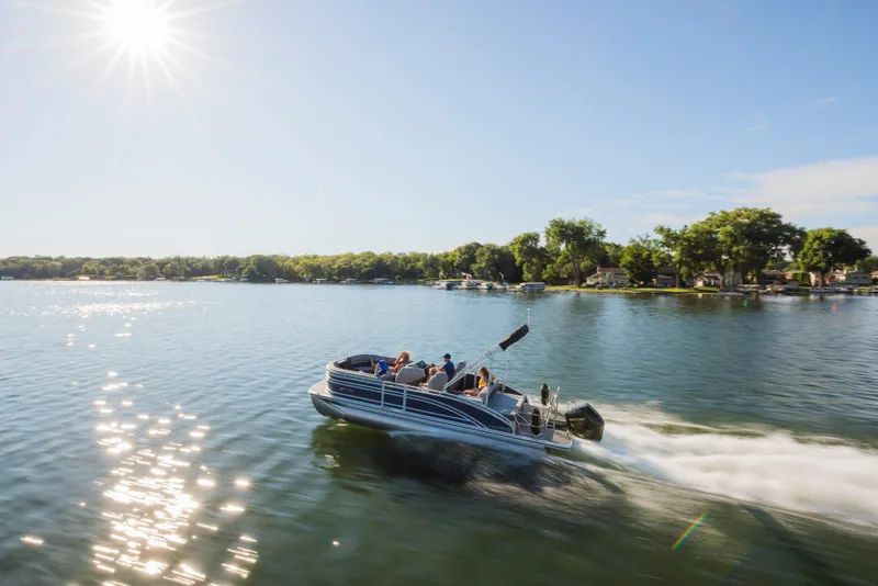 Slide: The Image of A Harris Solstice 230 pontoon boat speeds across a sunny lake. - 14