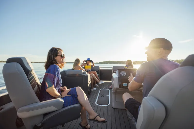 Slide: The Image of People relaxing on a Harris Solstice 230 pontoon boat on a calm lake. - 22