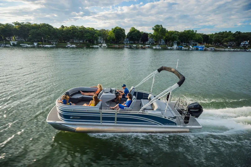 Slide: The Image of 2023 Harris Solstice 230 on a calm lake, with several people on board relaxing. - 26