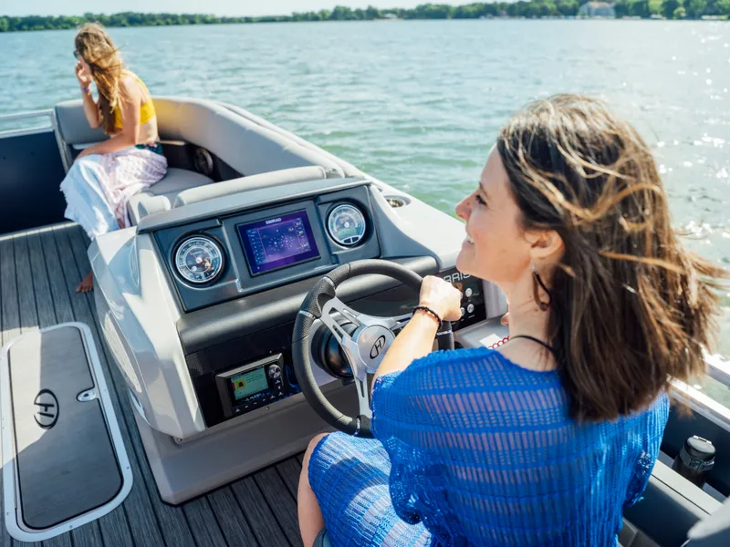 Slide: The Image of Two women relax on a Harris Solstice 230 boat on a lake. - 32