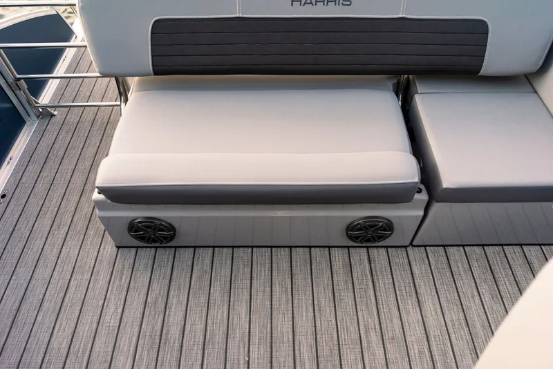 Slide: The Image of The image shows the seating area of a Harris Solstice 230 boat with gray upholstery and speakers. - 27
