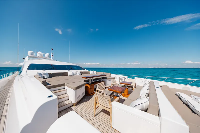 Slide: The Image of Luxurious 2009 Mangusta 165 yacht deck with elegant seating, ocean view, and clear blue sky. - 53