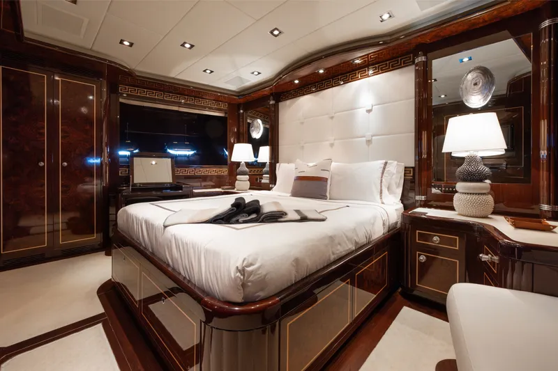 Slide: The Image of Luxurious bedroom interior on 2009 Mangusta 165 yacht, featuring elegant wood and plush bedding. - 41