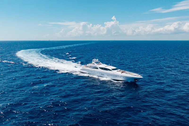 Slide: The Image of Luxurious 2009 Mangusta 165 yacht cruising on open blue ocean under clear sky. - 65