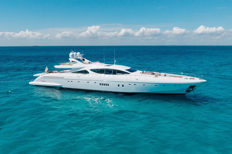Slide: The Image of Luxurious 2009 Mangusta 165 yacht cruising on clear blue ocean waters. - 1