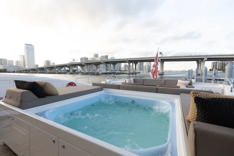Slide: The Image of Luxurious 2009 Mangusta 165 yacht with jacuzzi, city skyline, and bridge in the background. - 16