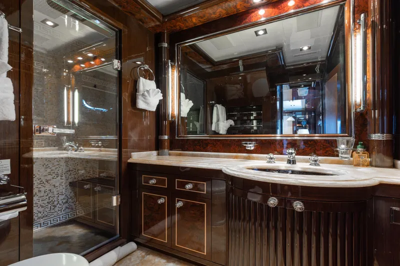 Slide: The Image of Luxurious bathroom interior on 2009 Mangusta 165 yacht, featuring elegant wood finishes and marble sink. - 43