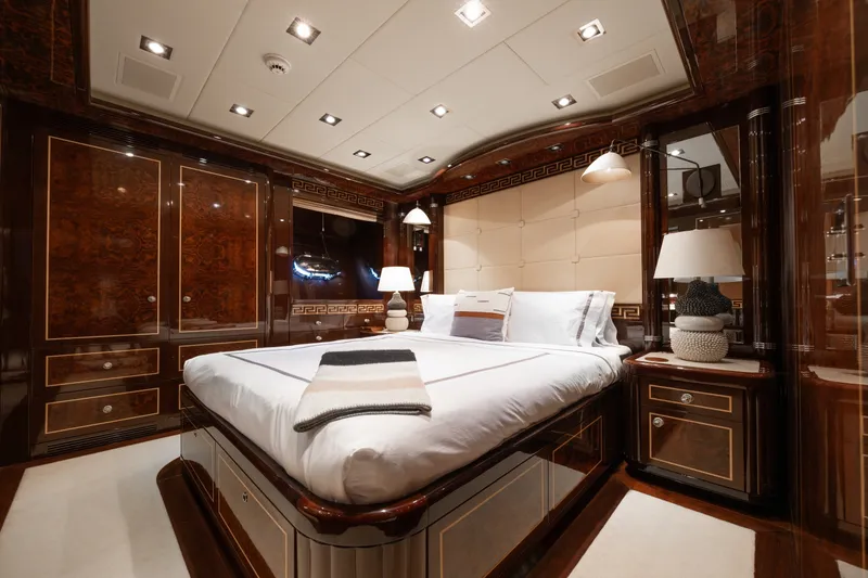 Slide: The Image of Luxurious bedroom interior on 2009 Mangusta 165 yacht, featuring elegant wood paneling and plush bedding. - 50