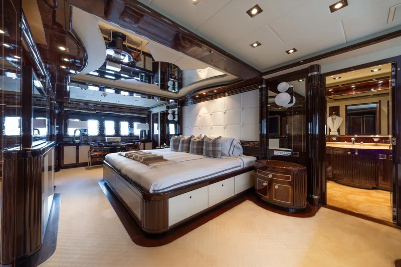 Slide: The Image of Luxurious bedroom interior on 2009 Mangusta 165 yacht, featuring elegant wood finishes and plush bedding. - 27