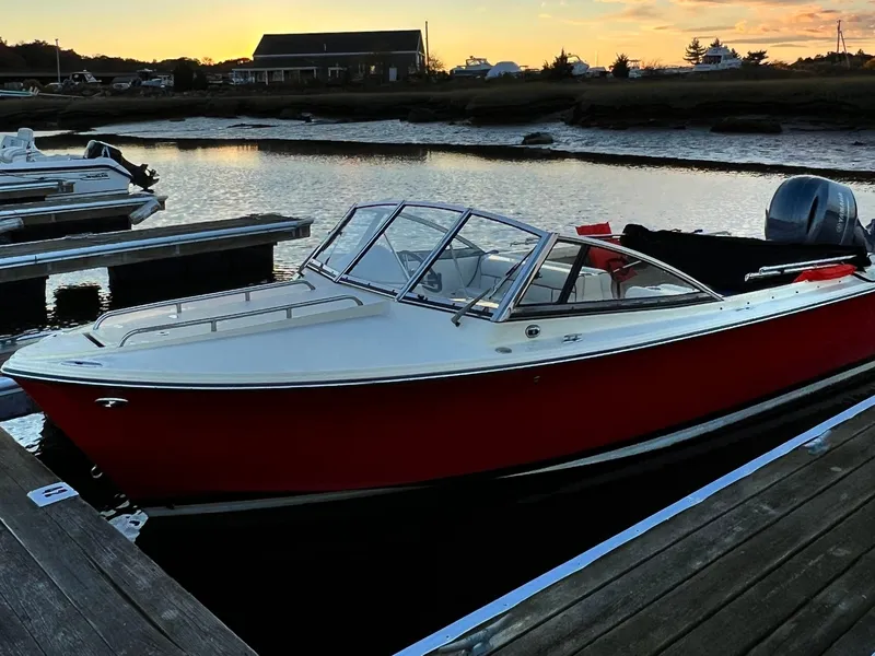 Slide: The Image of A sleek, red 2020 Rossiter 20 boat docked at a tranquil pier during sunset. - 2