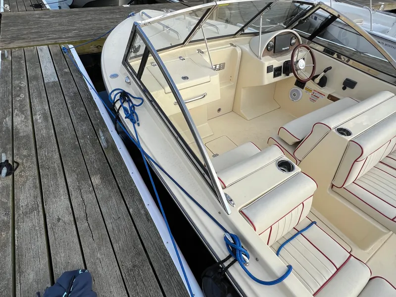 Slide: The Image of A 2020 Rossiter 20 boat docked at a wooden pier. It features cream seats with red accents. - 14