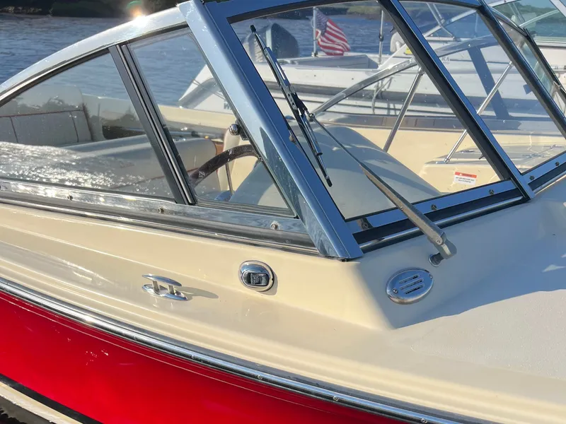 Slide: The Image of A 2020 Rossiter 20 boat with a red hull and chrome window frame. - 29