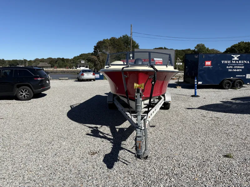 Slide: The Image of A red 2020 Rossiter 20 boat on a trailer in a gravel lot. - 8