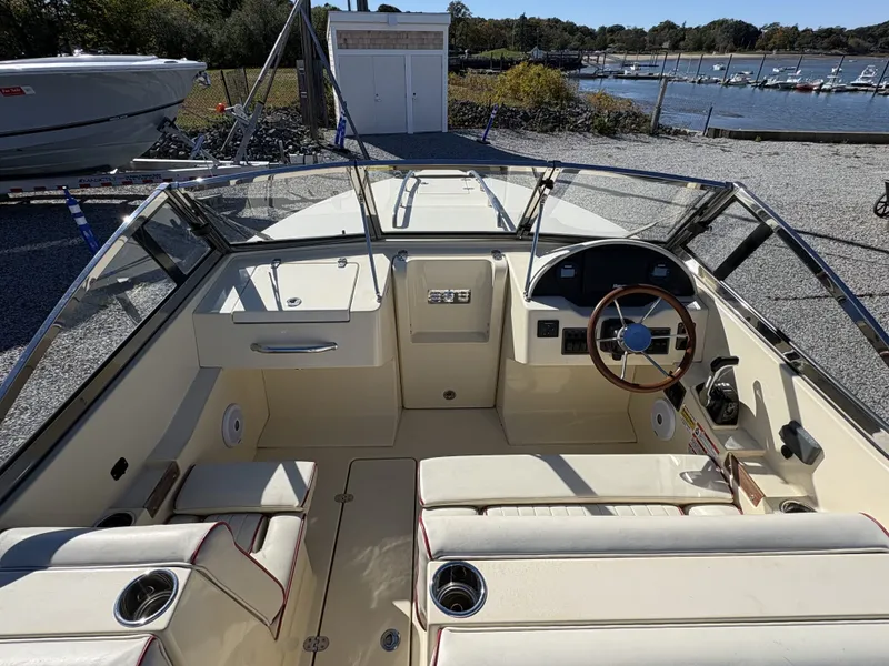 Slide: The Image of The image shows the cockpit of a 2020 Rossiter 20 boat with cream seats and a wooden steering wheel. - 21