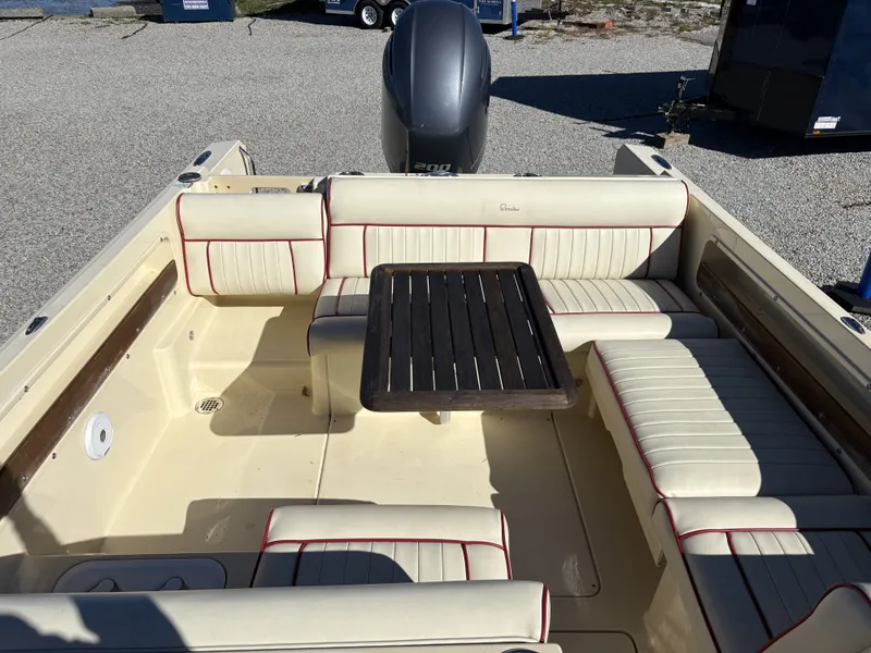 Slide: The Image of The image shows the cockpit of a 2020 Rossiter 20 boat with cream upholstery and a wooden table. - 17