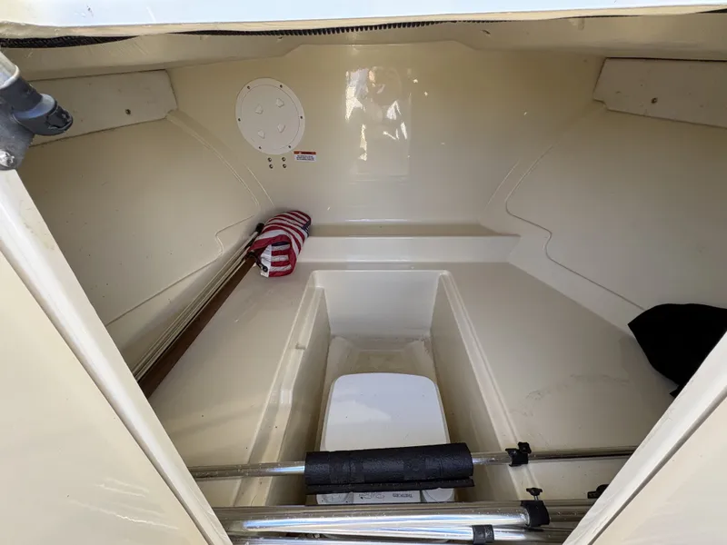 Slide: The Image of The image shows the storage area of a 2020 Rossiter 20 boat. It is clean and spacious. - 31