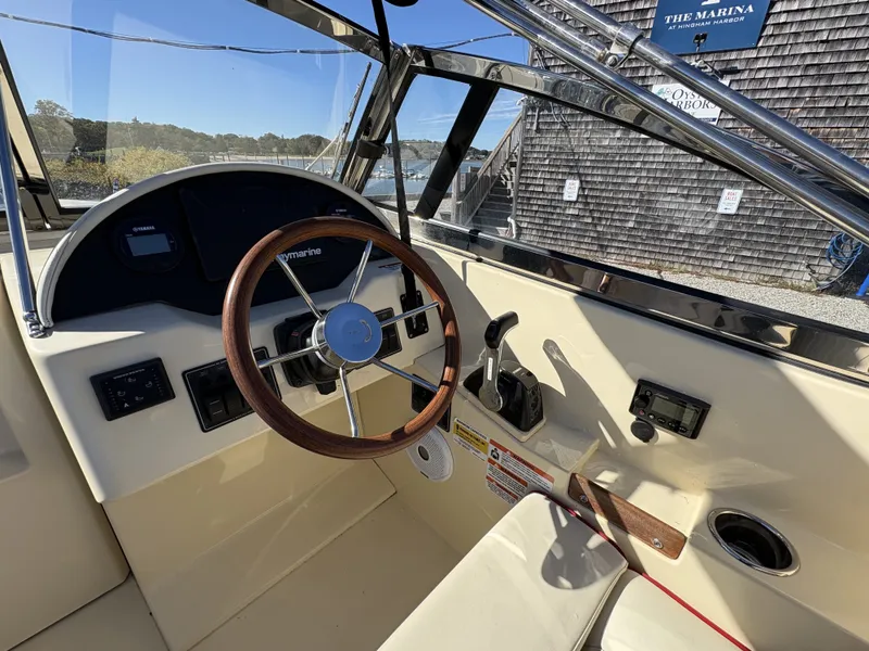 Slide: The Image of The image shows the cockpit of a 2020 Rossiter 20 boat with a wooden steering wheel. - 26